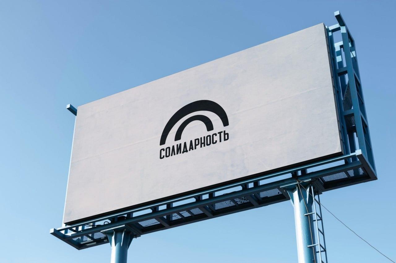 Визуализация чёрного логотипа «Солидарности» на светлом рекламном щите на фоне голубого неба